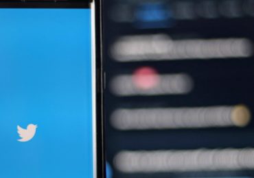 Twitter-on-phone-screen-next-to-blurred-timeline