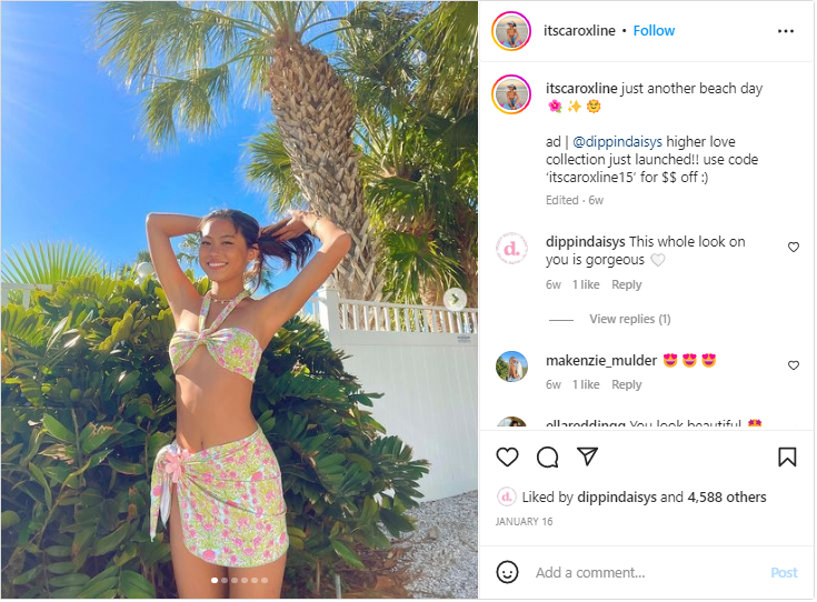 A brand ambassador, a young woman, stands outside under a palm tree modeling a bikini.