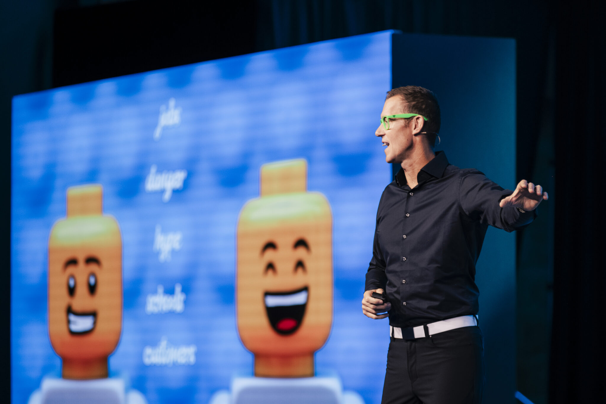 AI Speaker, Erik Qualman, on stage with slide on AI behind him.